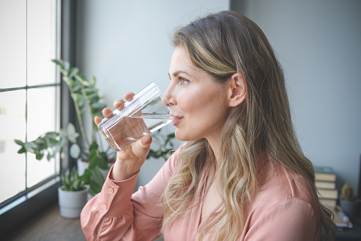 kobieta pije wodę ze szklanki